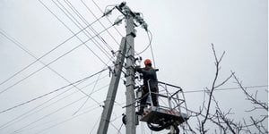 Енергетик ремонтує лінії електропередач (Фото:REUTERS/Valentyn Ogirenko)